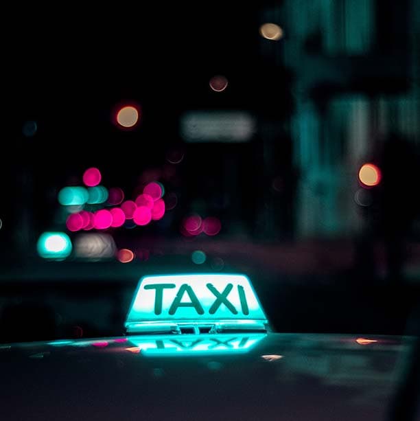 A taxi sign illuminated at night